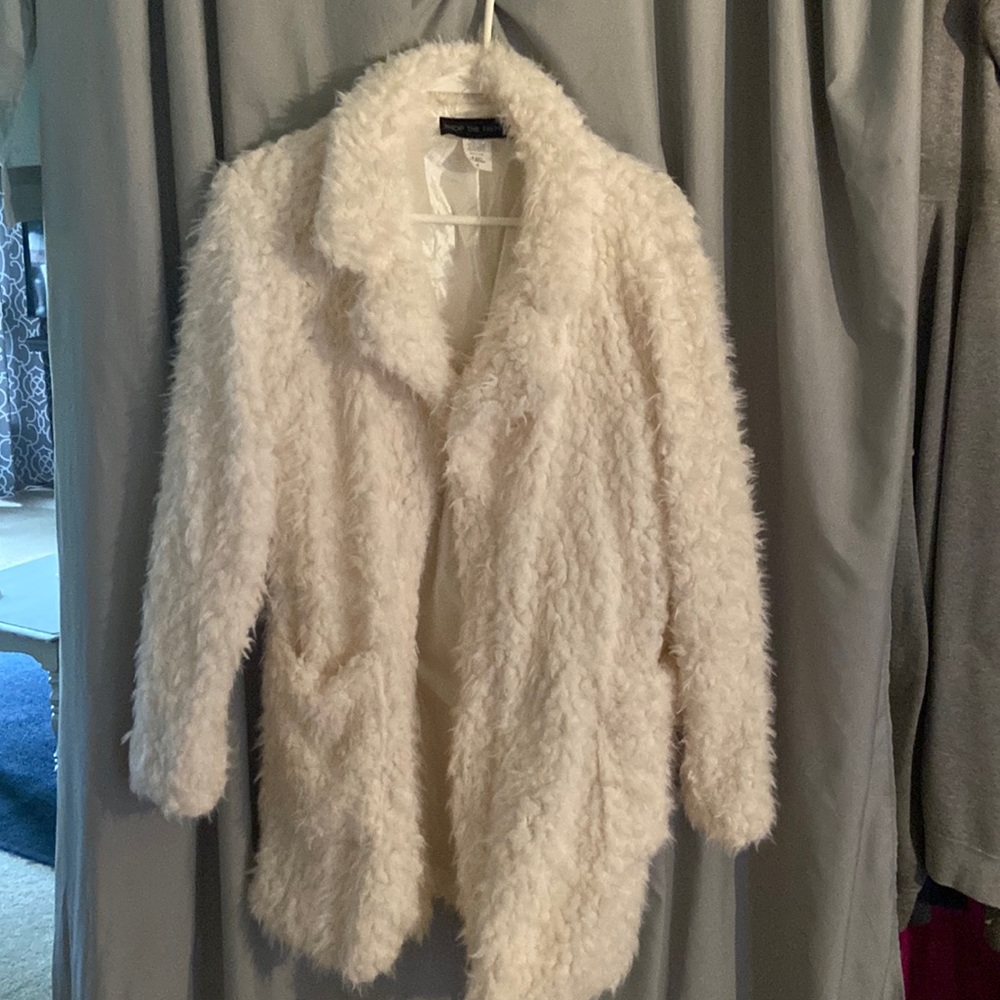 Cream soft fuzzy dress jacket with polyester lining. Deep pockets on side.